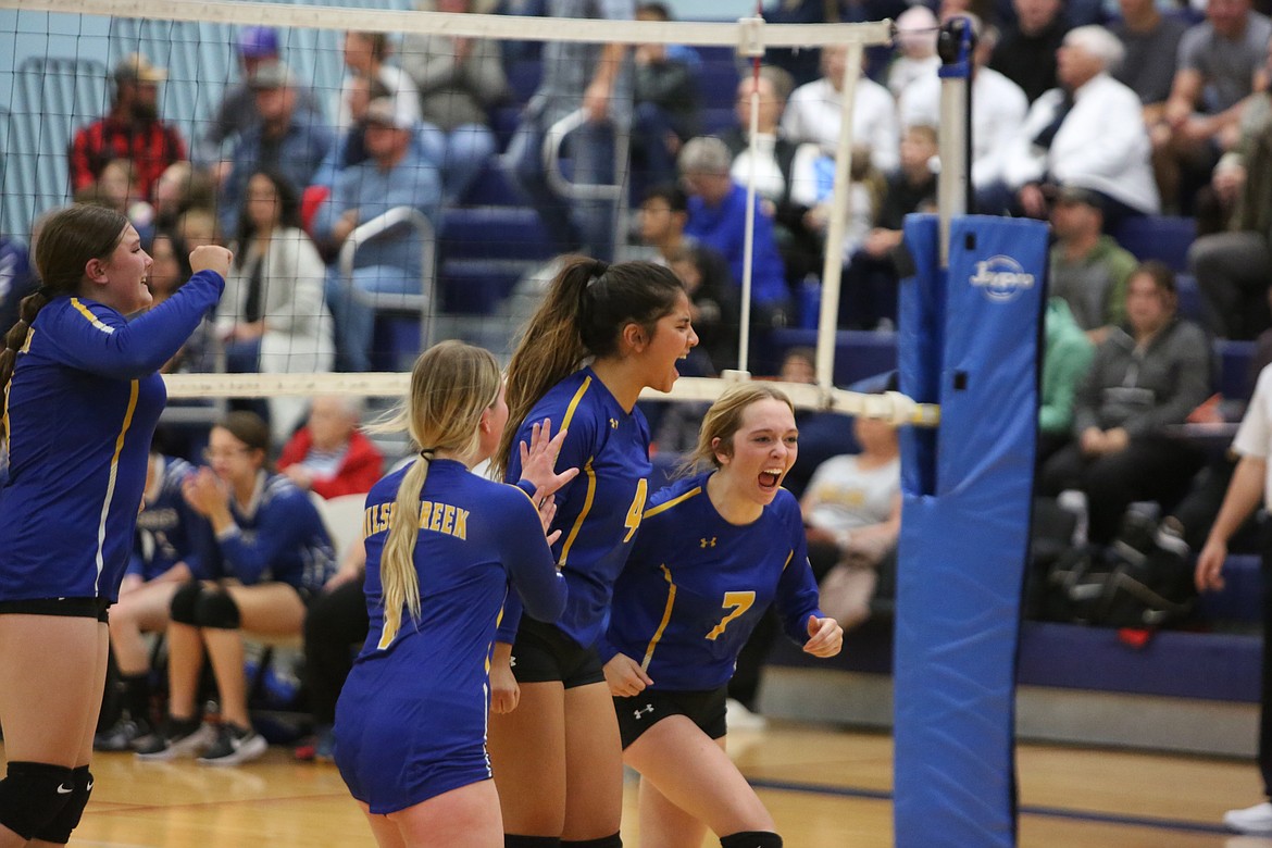 Wilson Creek players Neeley Odorizzi (left), Cassie Hinen (middle left), Lucy Cioccolini (middle right) and Izzie Hochstatter (right) celebrate after the Devils defeated Soap Lake on Thursday.