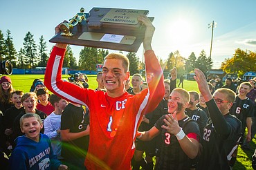 Columbia Falls goalkeeper Bryce Dunham (1) celebrates with the state championship trophy after the Wildcats' 5-2 win over Livingston at Flip Darling Memorial Field in Columbia Falls on Saturday, Oct. 29. (Casey Kreider/Daily Inter Lake)