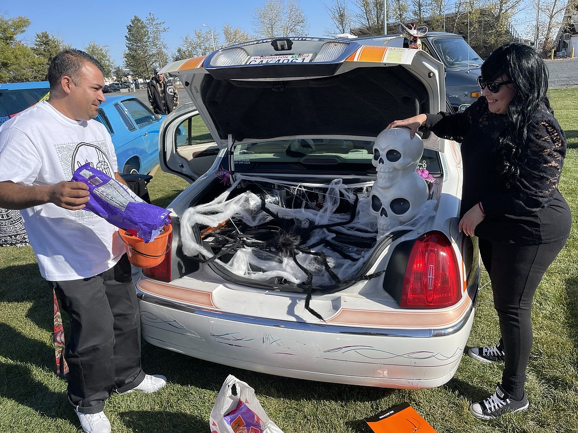 Wenatchee residents Oscar Garcia and Lily Estrada decorate their car in preparation for trunk or treat during the Moravida Festival at the Grant County Fairgrounds on Saturday.