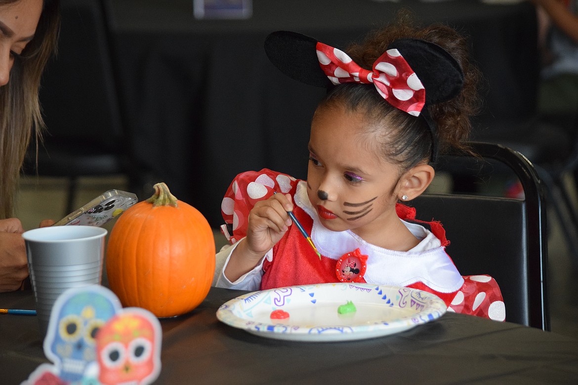 Sophia Osoria, 4, of Moses Lake, paints a pumpkin for Halloween — one of the many activities available for children and adults at the Moravida Festival on Saturday.