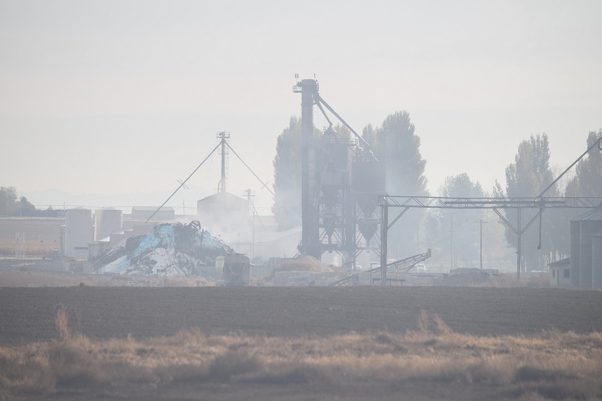 The smoldering remains of the Wilbur-Ellis fertilizer facility on Road 1.3 SE. The Grant County Health District expanded the advisory area around the plant to two miles late Friday, saying work crews would begin excavating the charred remains Saturday morning.