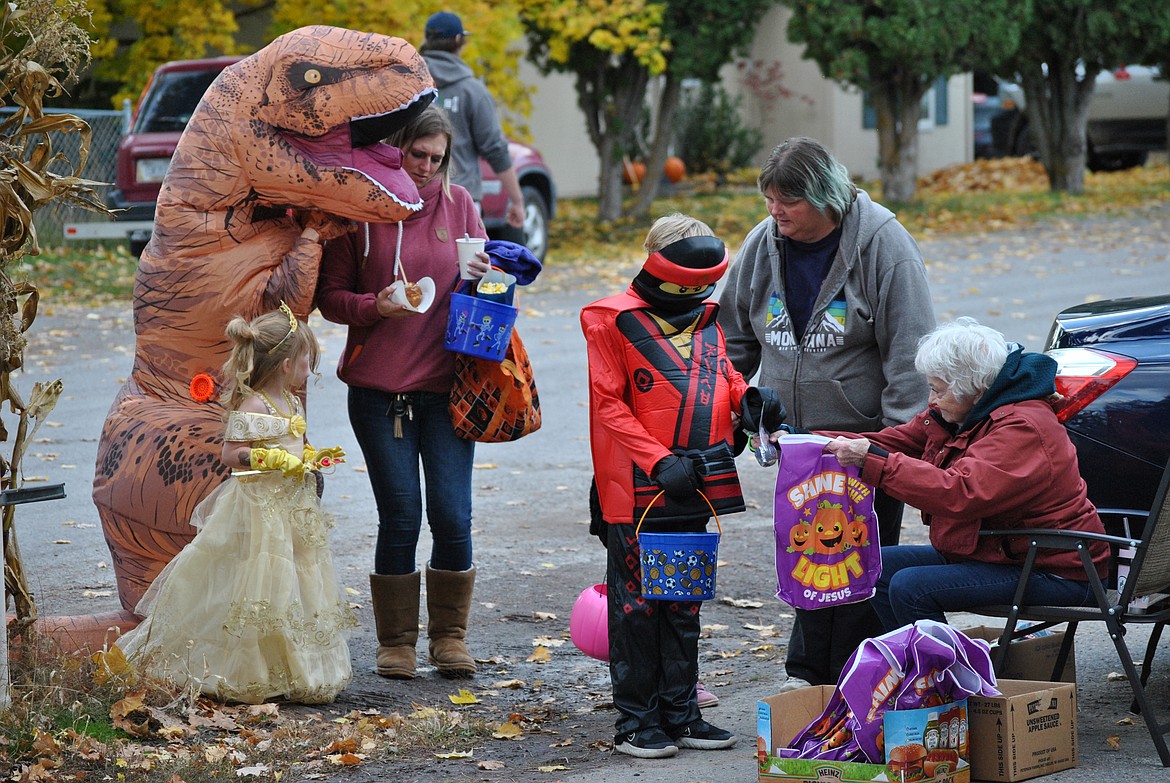 Kathy McClelland hands out candy to a fun variety of costume wearers during the trunk or treating at the Fall Festival in St. Regis. (Amy Quinlivan/Mineral Independent)