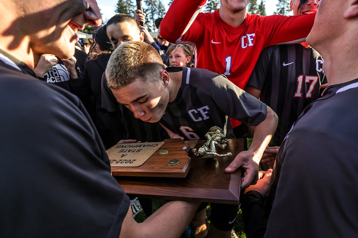 Senior Dale Blickhan emotionally embraces the State A title trophy after the match on Saturday. (JP Edge photo)