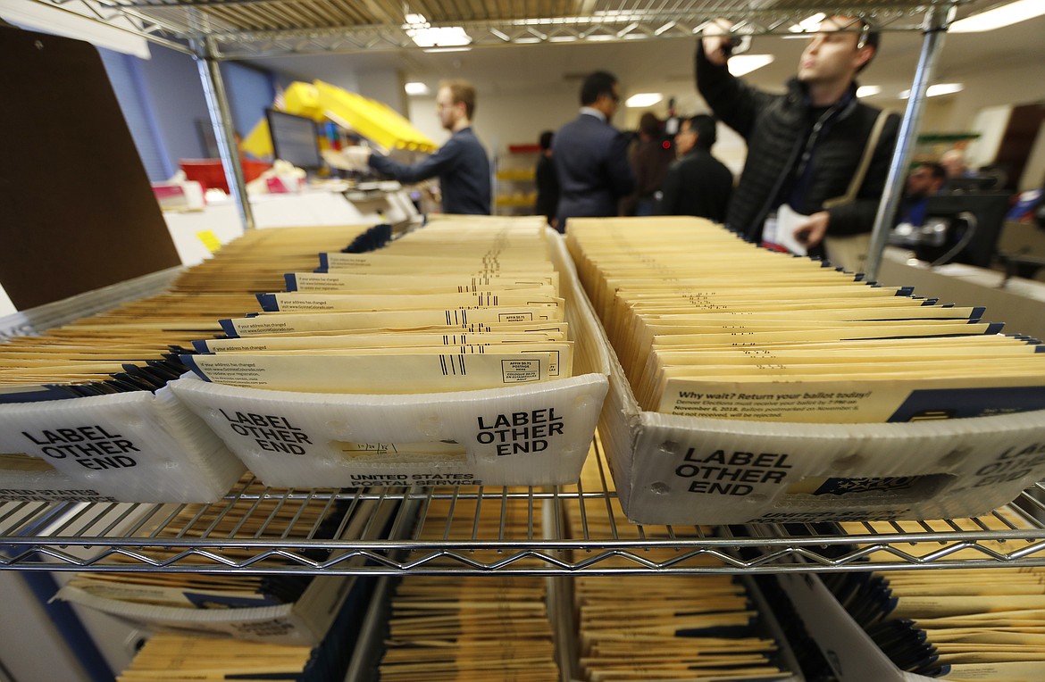 Early ballots wait in bins to be sorted in the Denver Elections Division headquarters in Denver in 2018. On Friday, The Associated Press reported on stories circulating online incorrectly claiming Colorado’s practice of sending mail-in ballots to every registered voter is unconstitutional, and voters should only vote in person on Election Day.