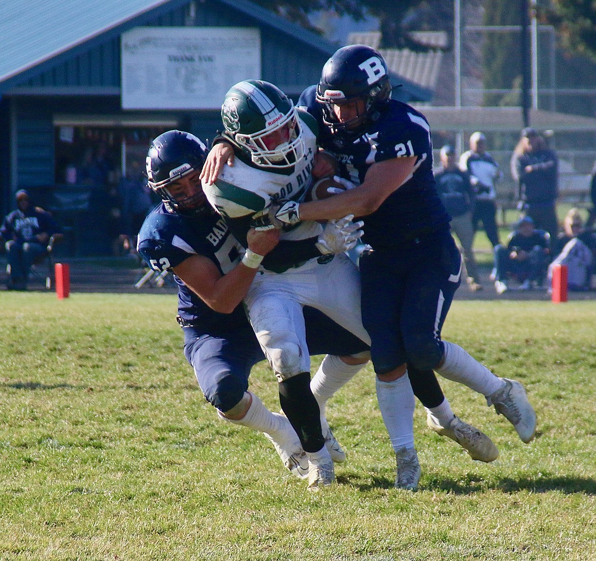 Wood River player tackled by #52 Dillion Mai and #21 Cleo Henslee at the playoff game.