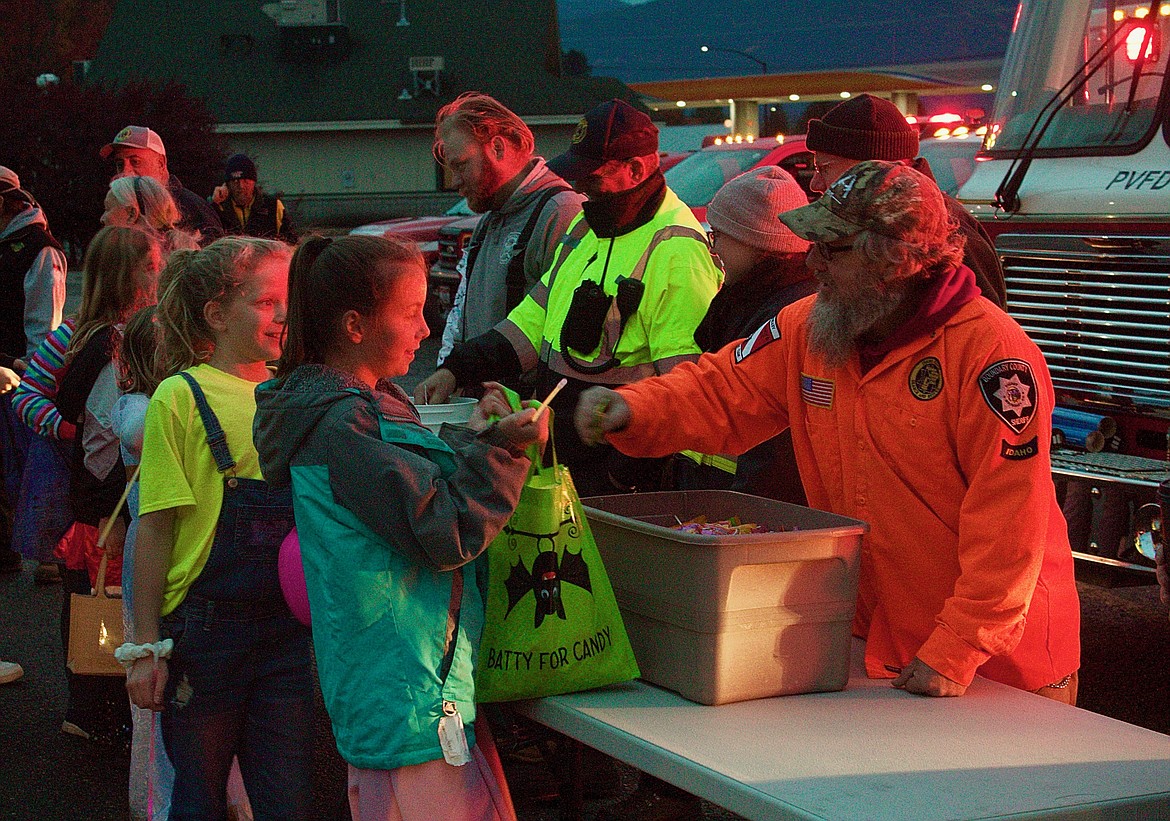 Trick-or-treaters at Glowing Treats event with first responders at the BCMS parking lot.