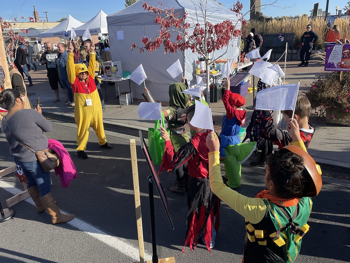 Costumed trick-or-treaters play Simon Says near Sinkiuse Square during the Harvest Festival in downtown Moses Lake on Saturday.