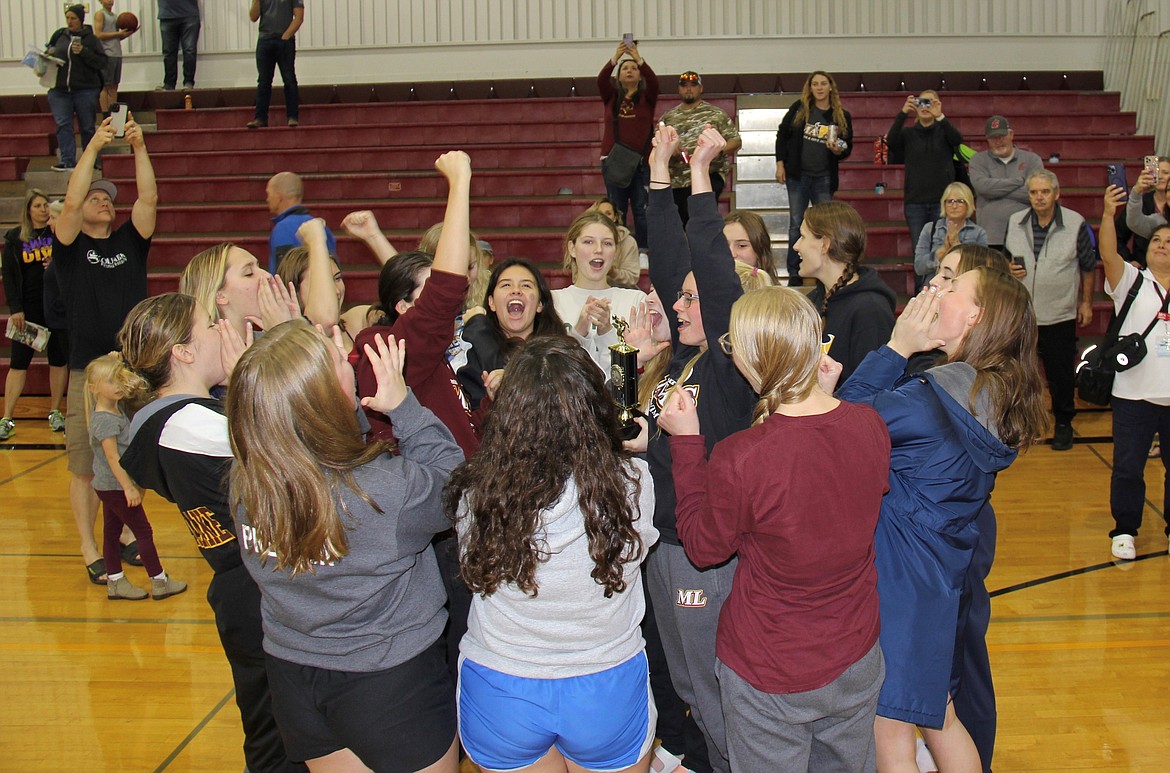 The Moses Lake Maverick girls’ swim and dive team celebrates with the district championship trophy.