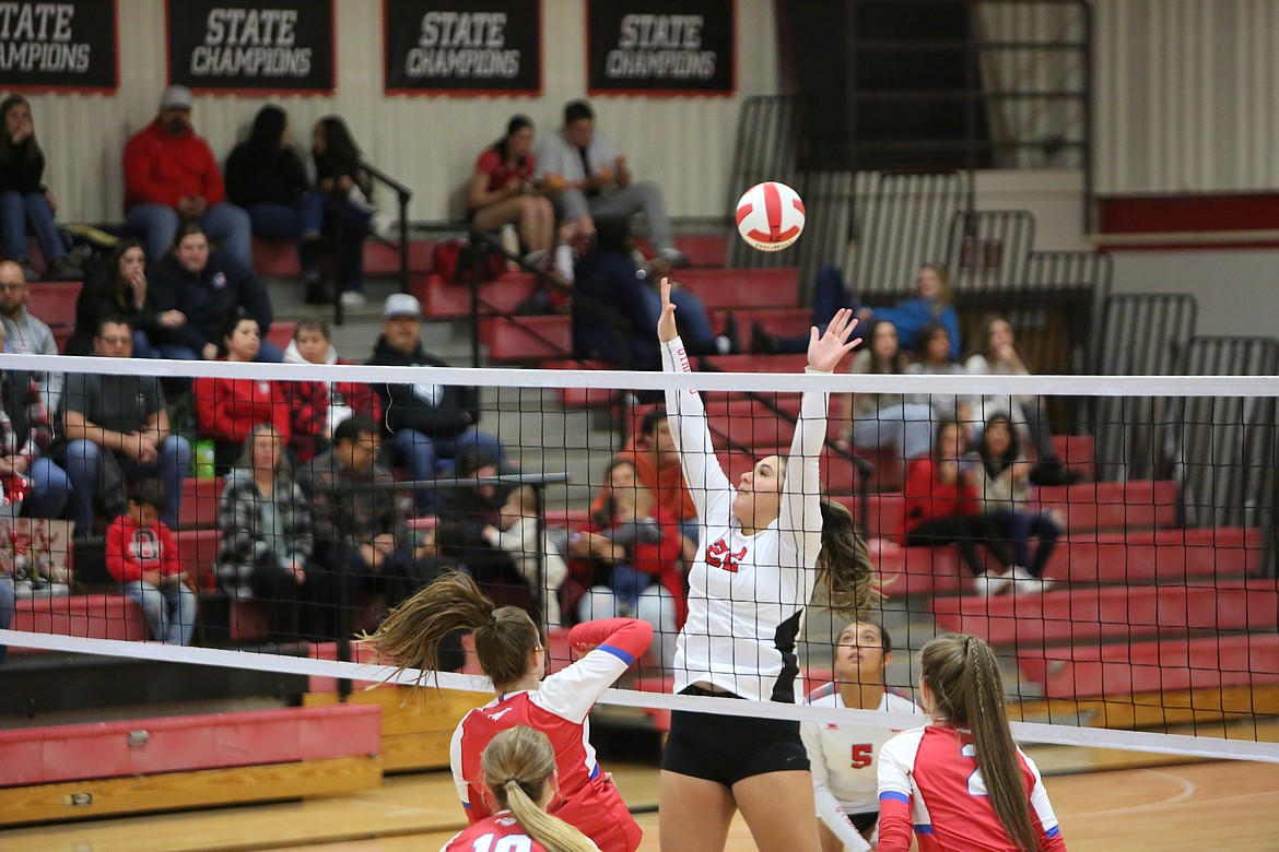 Othello junior Alize Alvarez raises her arms into the air to block the ball against Prosser on Tuesday.