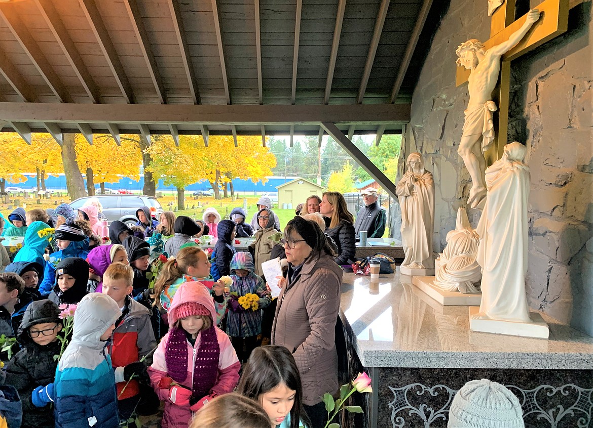 Holy Family Catholic School students gather in the shrine area at St. Thomas Catholic Cemetery on Wednesday for a presentation by Williene Gagnon and Annemarie Lander of the  cemetery committee.