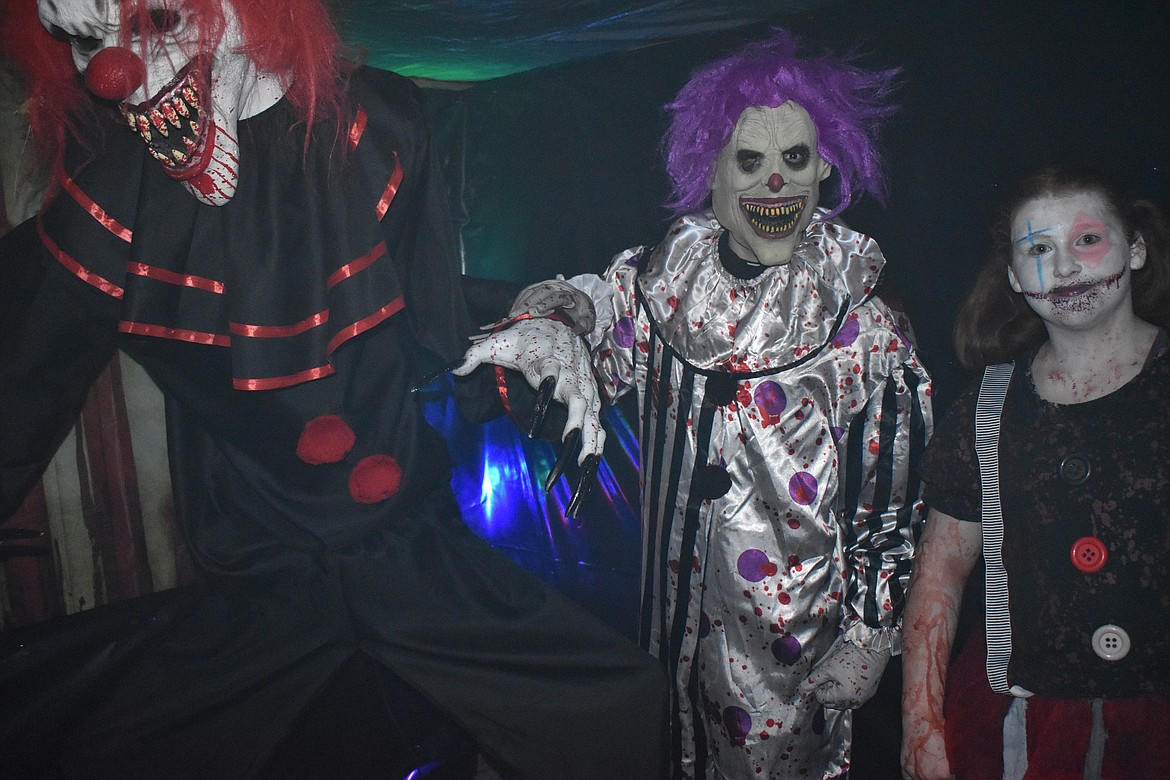 Scarers Derrick Knigge and Ciera Hart, middle and right respectively, pose in the Living Nightmare Haunted Attraction maze