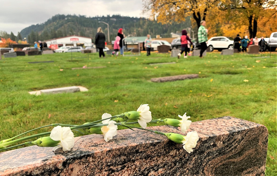 Flowers left by Holy Family Catholic School students rest on a headstone at St. Thomas Catholic Church on Wednesday, All Souls Day.