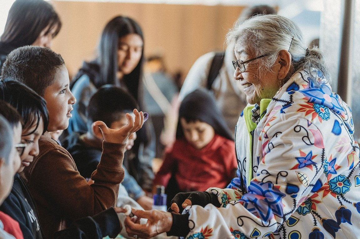 Wanapum Elder Ernestine Conner gives kids a close-up look at hand-woven textiles.