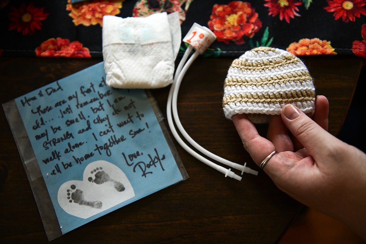 Breanna Villanueva shows hospital items from the premature birth of her son Rocky, who was born at 25 weeks. Shown are a note from her NICU nurse with the footprints of her son; a preemie 3 diaper; a tiny blood pressure cuff; and a newborn hospital hat at Villanueva's home in Kalispell on Wednesday, Nov. 2. (Casey Kreider/Daily Inter Lake)