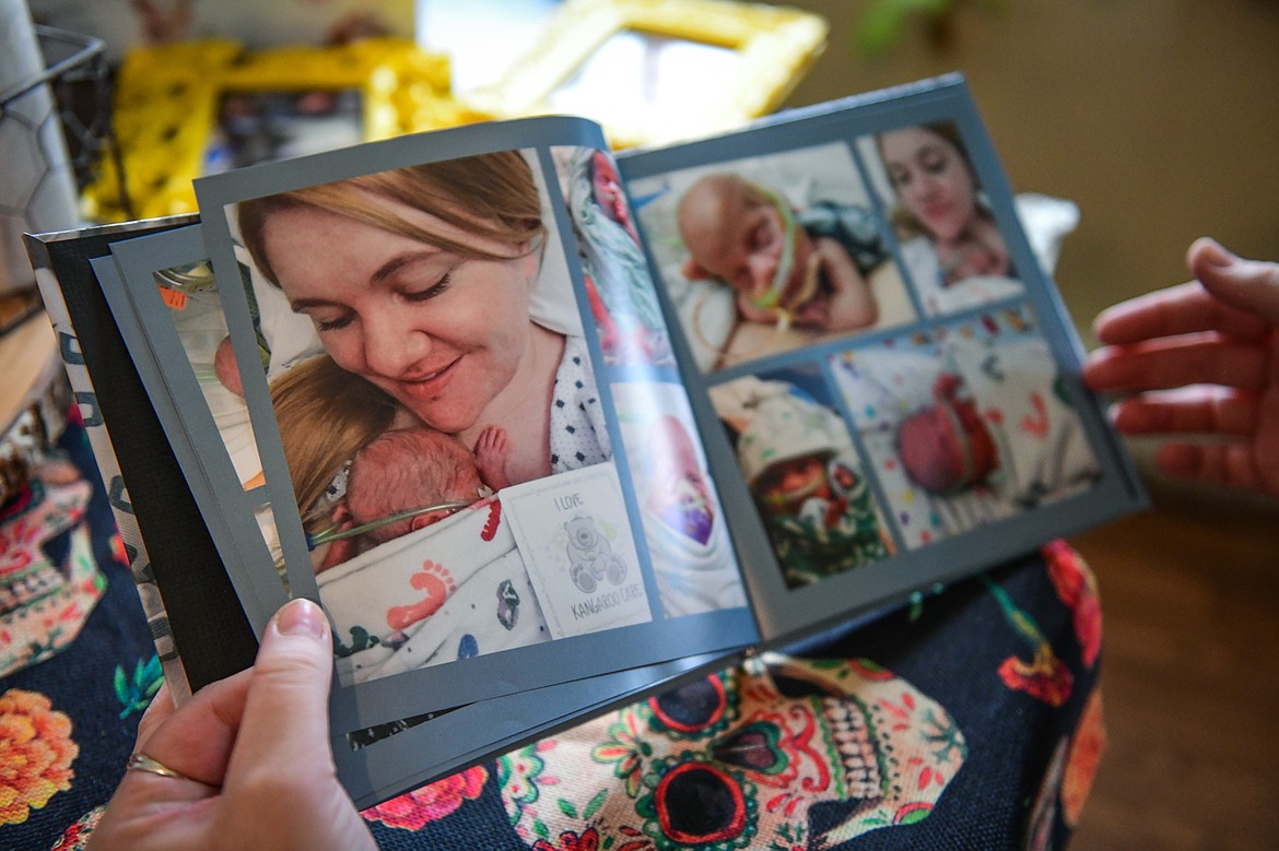 Breanna Villanueva pages through a photo book from the birth of her son Rocky at her home in Kalispell on Wednesday, Nov. 2. (Casey Kreider/Daily Inter Lake)