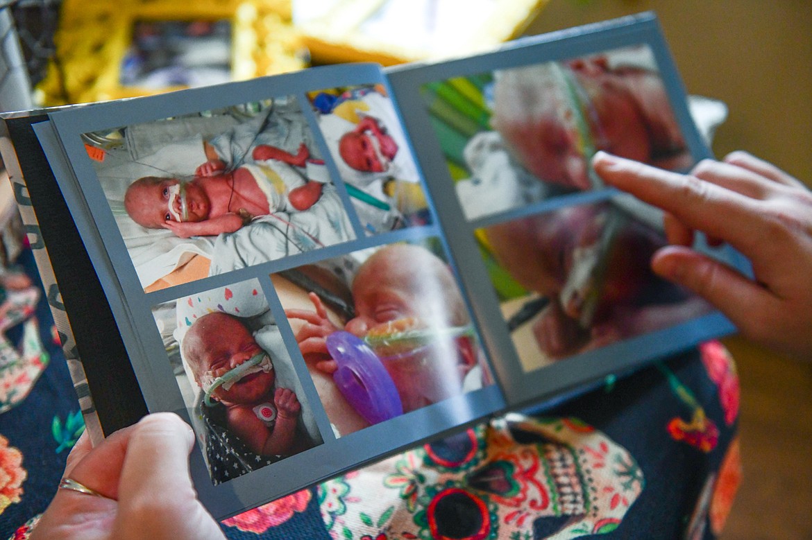 Breanna Villanueva pages through a photo book from the birth of her son Rocky at her home in Kalispell on Wednesday, Nov. 2. (Casey Kreider/Daily Inter Lake)