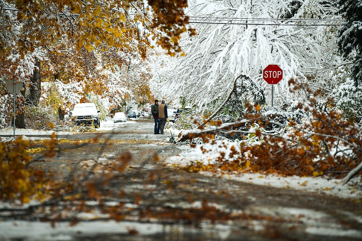 Two residents chat in the middle of a debris-lined Second Avenue East in Kalispell on Thursday, Nov. 3. (Casey Kreider/Daily Inter Lake)