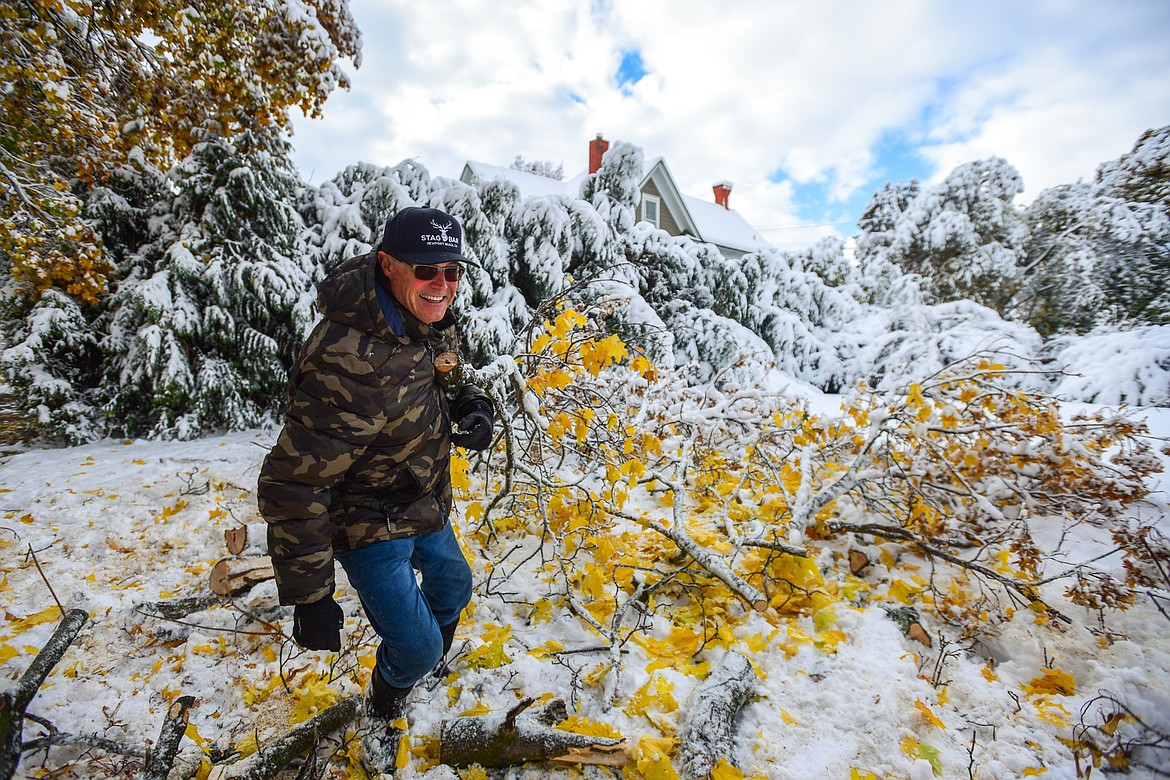 Ron Runnels clears downed tree limbs and debris from his property on Fifth Avenue East in Kalispell on Thursday, Nov. 3. (Casey Kreider/Daily Inter Lake)