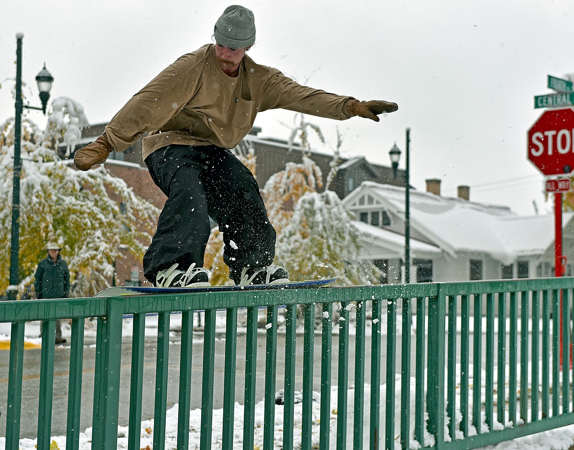 Colton Bliss ollies his snowboard onto a fence rail, pulled by his friend Josh Oliver at their friend Emily Lacoste's place on Central Avenue in Whitefish on Thursday. The three friends were stoked on the first valley snow of the season as Whitefish accumulated around six inches of snow last Wednesday. (Whitney England/Whitefish Pilot)