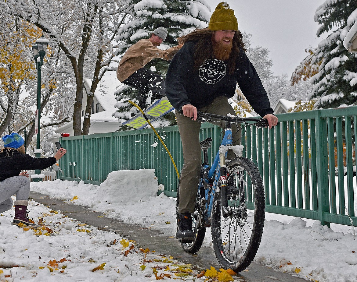 Colton Bliss ollies his snowboard onto a fence rail, pulled by his friend Josh Oliver at their friend Emily Lacoste's place on Central Avenue in Whitefish on Thursday. The three friends were stoked on the first valley snow of the season as Whitefish accumulated around six inches of snow last Wednesday. (Whitney England/Whitefish Pilot)