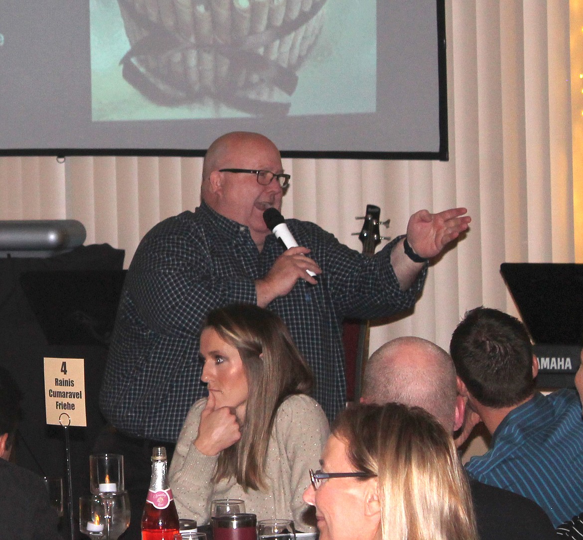 Auctioneer Patrick Siver delivers a rapid-fire patter during the dessert frenzy at the Moses Lake Christian Academy Saturday. A couple of cakes brought in more than $2,000 each, organizers said.