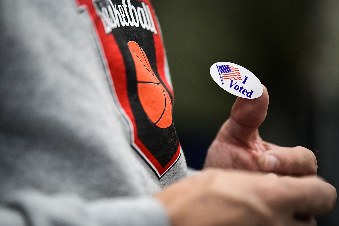 A voter holds an "I Voted" sticker on his thumb after casting his ballot at the Trade Center at the Flathead County Fairgrounds on Tuesday, Nov. 8. (Casey Kreider/Daily Inter Lake)