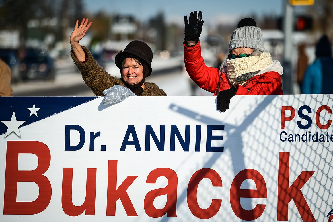 Dr. Annie Bukacek, left, Republican candidate for Montana Public Service Commission, waves to passing motorists with Margo Delapp, right, outside the Flathead County Fairgrounds on Tuesday, Nov. 8. (Casey Kreider/Daily Inter Lake)