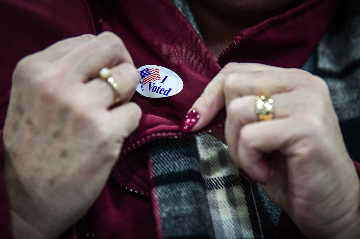 A voter places an "I Voted" sticker on her coat after casting her ballot at the Trade Center at the Flathead County Fairgrounds on Tuesday, Nov. 8. (Casey Kreider/Daily Inter Lake)