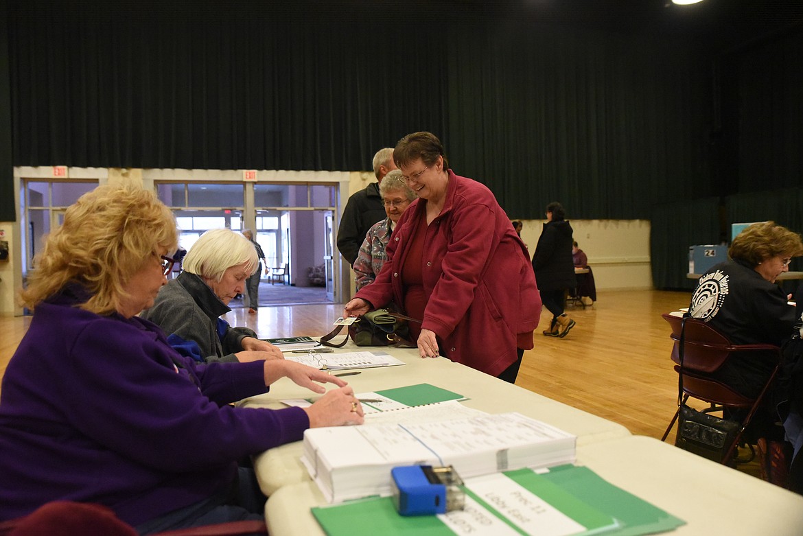 Libby voters Kayleen Munsell (red jacket) and Rose Munsell are checked in by poll workers Donna Martin and Veronica Bovee-Anderson on the morning of Tuesday, Nov. 8 at the Libby Memorial Events Center. (Scott Shindledecker/The Western News)