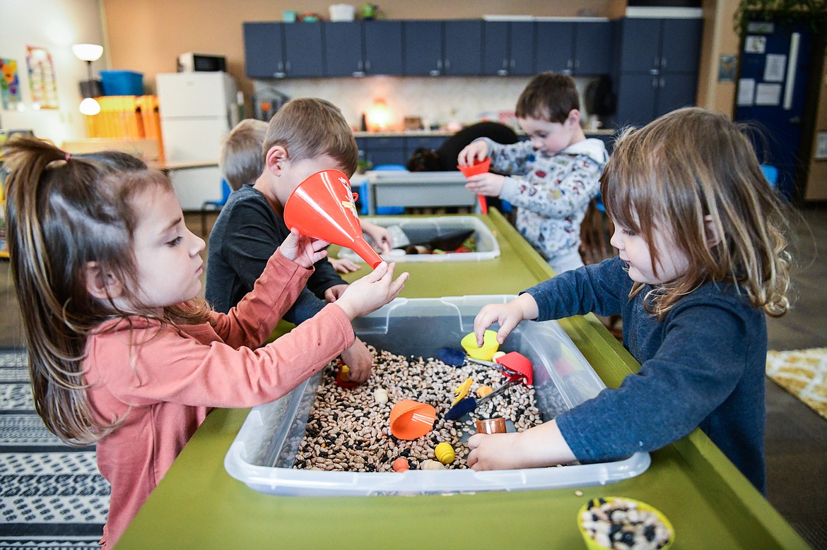 Kids play at a sensory table at The Hive Daycare inside Peterson Elementary School in Kalispell on Wednesday, Nov. 9. (Casey Kreider/Daily Inter Lake)