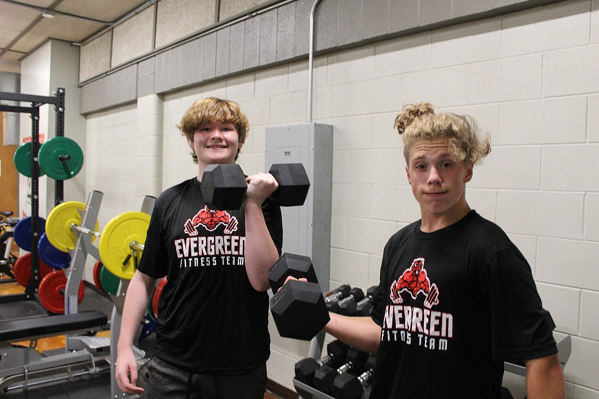 Evergreen Fitness Team participants Talon Maher, left, and Tristan Hall, right, lift weights during the 2022 summer session. Weightlifting is one component of the Evergreen Fitness Team. Participants also access cardio equipment and play popular games such as basketball and dodgeball in addition to making up games that keep them active during each session. (Photo provided by Ross Darner)