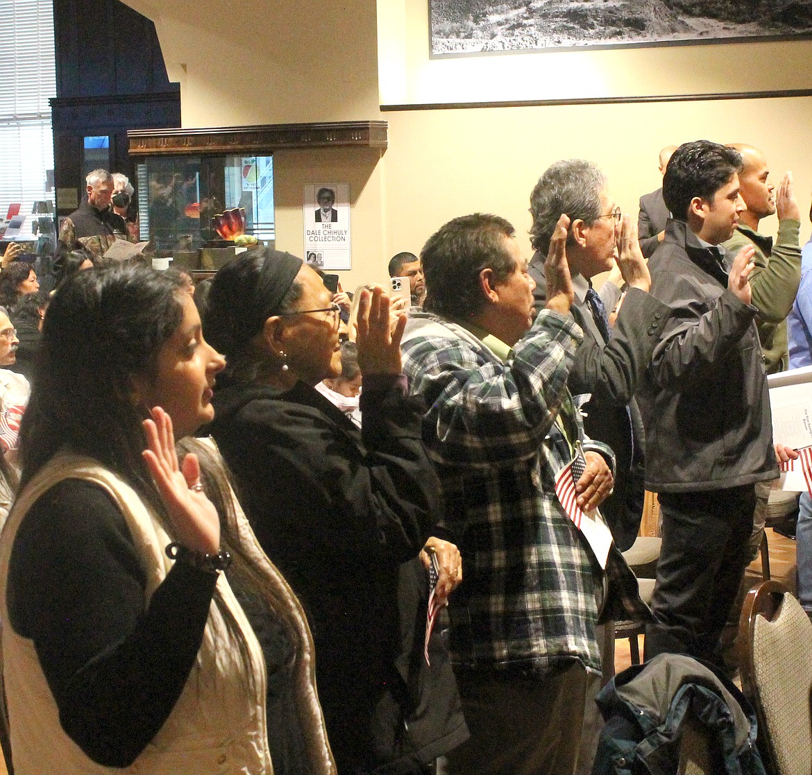 Twenty-five people raise their right hands and swear their allegiance to the United States as citizens Tuesday during a naturalization ceremony in Wenatchee.