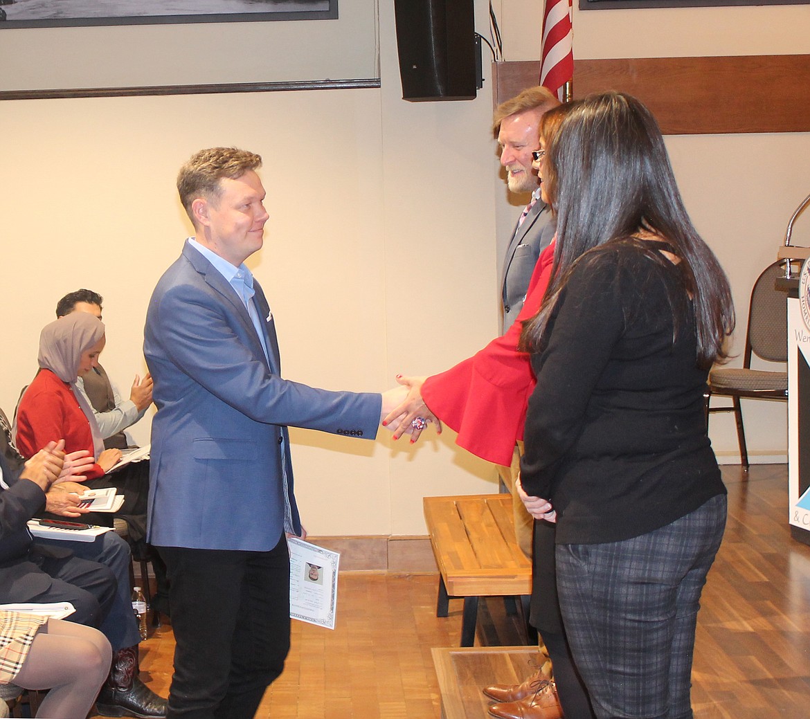 Oleg Demchenko steps forward to receive his citizenship certificate Tuesday in Wenatchee.