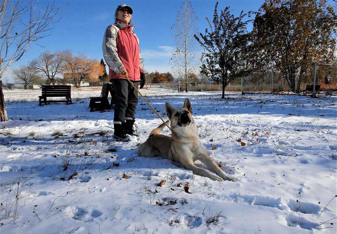 Denise Whitmore and Keith stop during a walk in the snow at the Kootenai Humane Society on Wednesday.