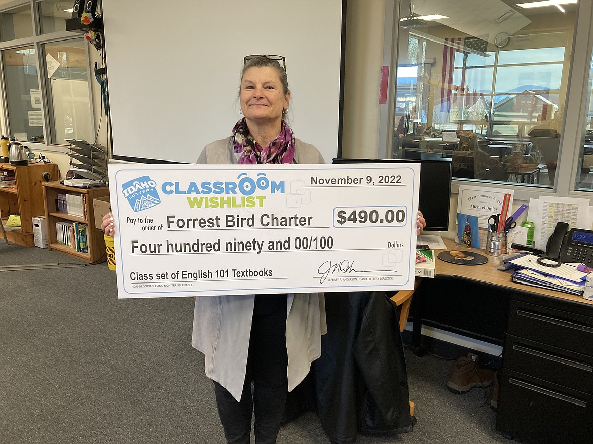 Forrest Bird Charter Mitzi Vesecki poses with a grant award from Idaho Lottery. The grant will allow the school to buy English 101 textbooks for students.