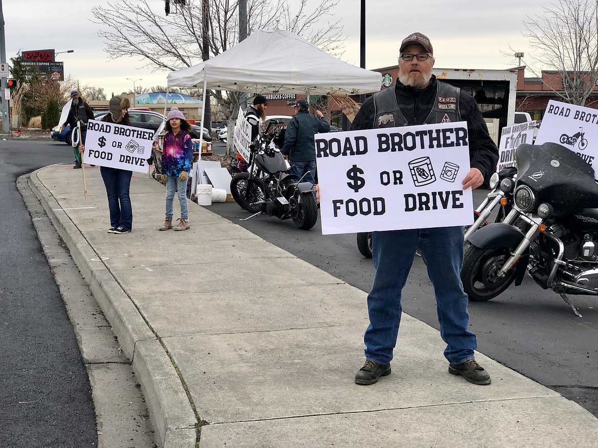 A member of the Road Brothers Northwest motorcycle club solicits donations in the fall of 2020. Club members will be out on N. Stratford Road on Saturday, Nov. 12, again soliciting donations of non-perishable food items and cash to help local families.