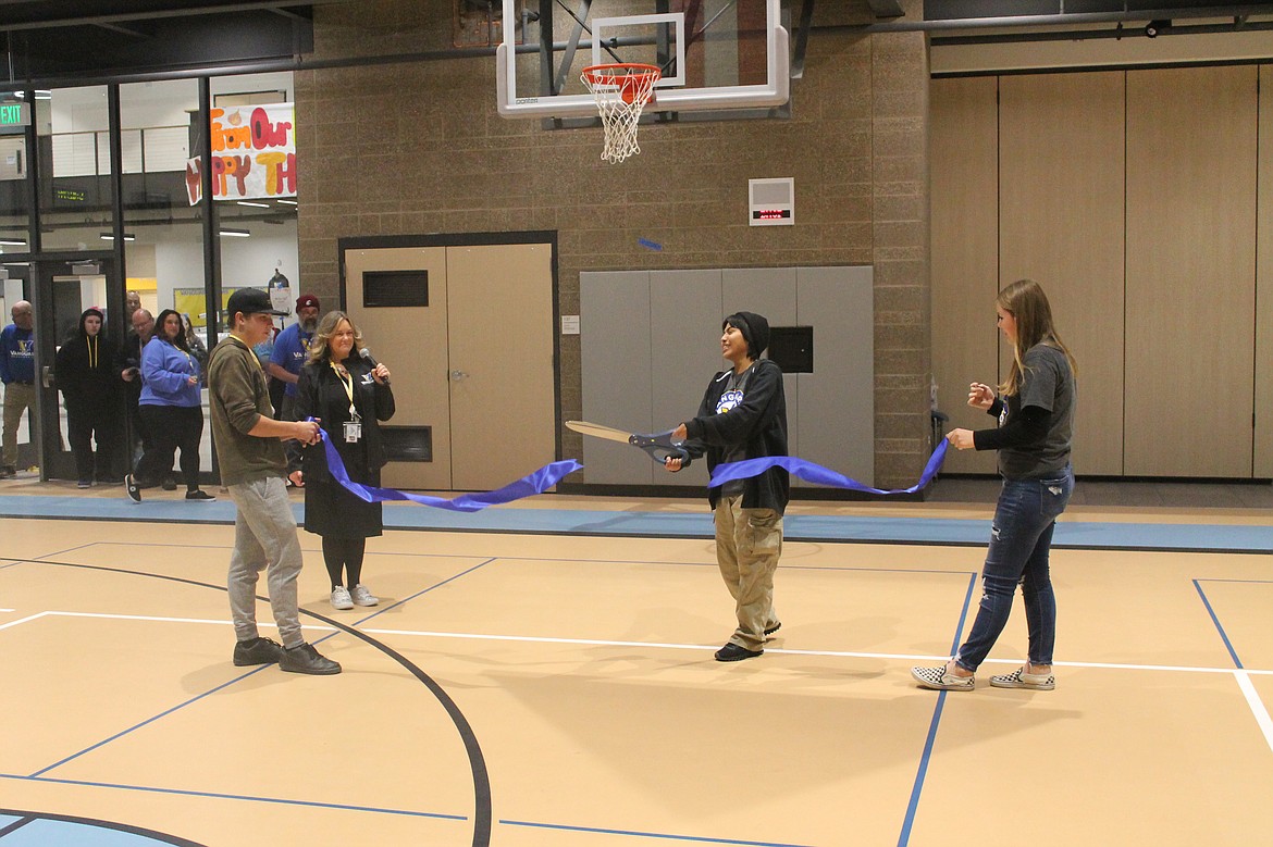 Vanguard Academy Principal Kelly Cutter beams in the background while students (from left) Seth Smith, Selena Raimrez and Halle Gies cut the ceremonial ribbon at Moses Lake School District’s newest campus Wednesday evening.