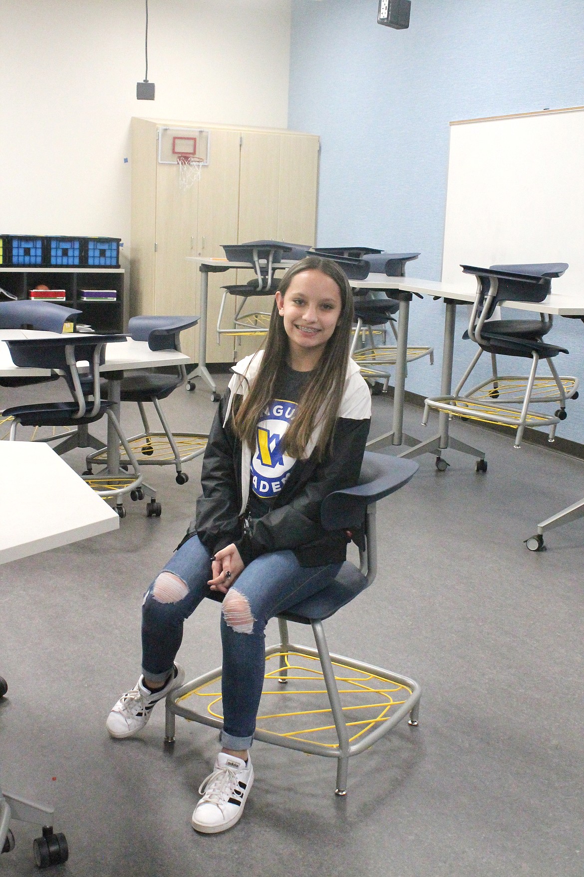 Vanguard student and tour guide Alyssa Wassink demonstrates a special chair available at the school for students who have difficulty sitting still.