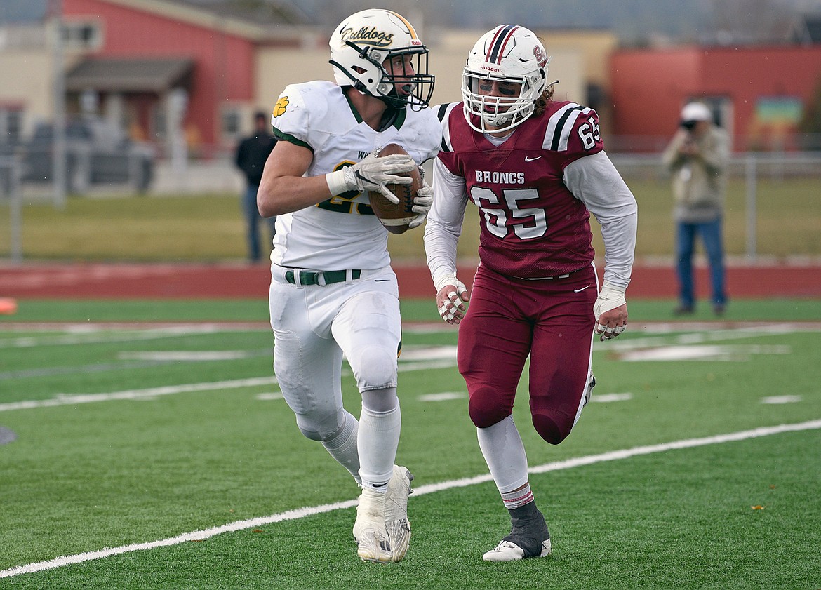 Bulldog Ty Schwaiger looks to throw the ball in a quarterfinal playoff game against Hamilton Saturday. (Whitney England/Whitefish Pilot)