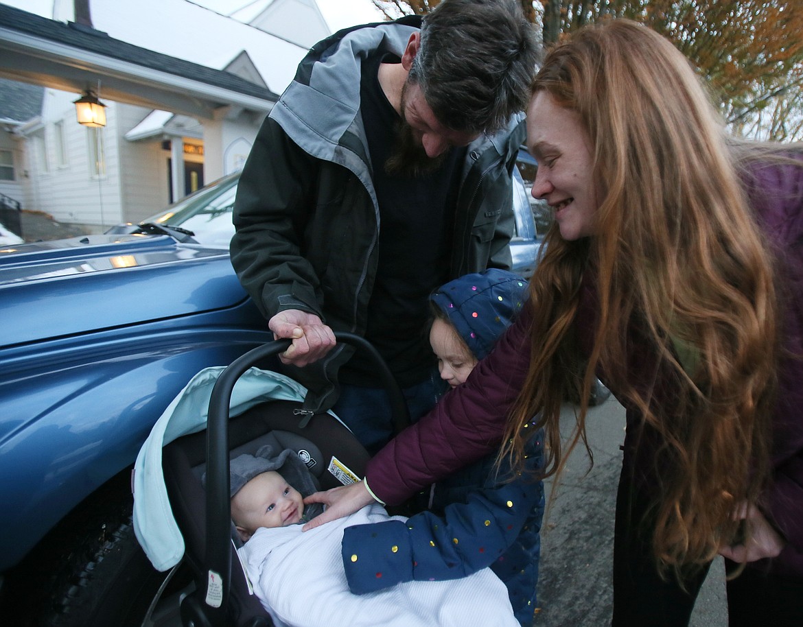 Josh France, Brooke Carroll and their 5-year-old daughter Abigail dote on 3-month-old baby David outside of the Family Promise office Thursday in downtown Coeur d'Alene. The struggling family recently received the gift of a reliable used vehicle from an anonymous local donor.