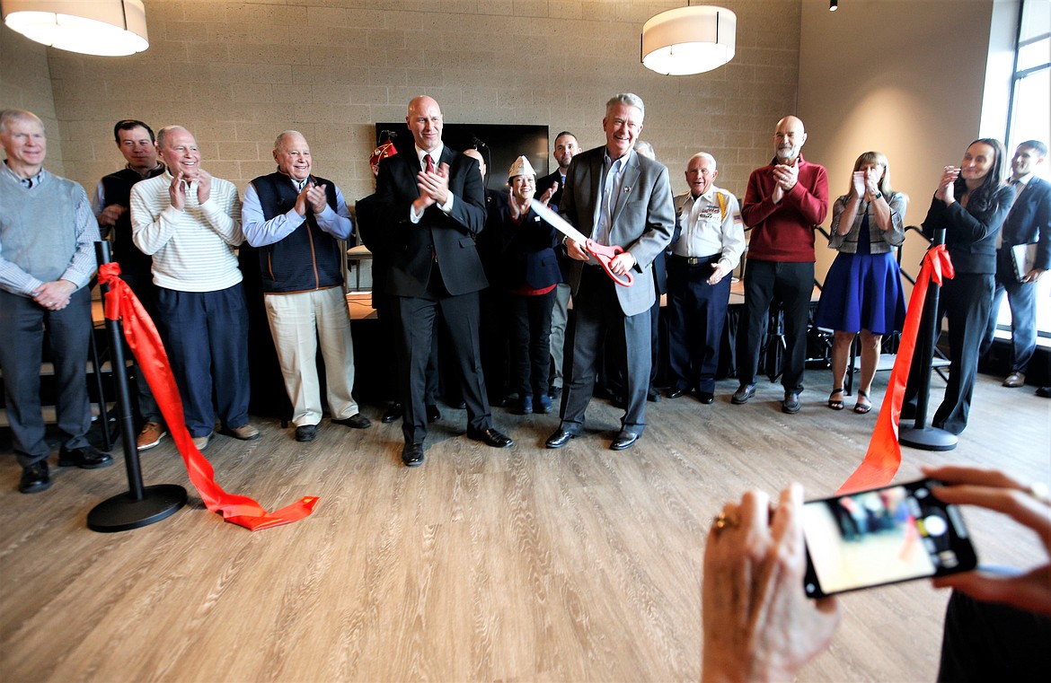 Gov. Brad Little holds the scissors as others applaud following the ribbon-cutting for the dedication of the Veterans Home in Post Falls on Friday.