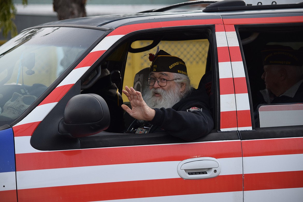 A veteran waves to the crowd as the annual Veterans Day parade makes its way down Basin Street in Ephrata on Friday.