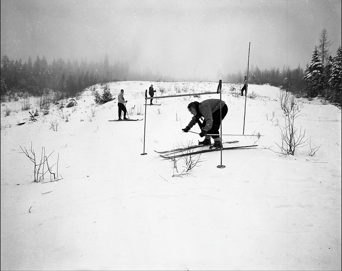 Sally (Holz) Parsons skis under the limbo pole at the Pine Street Run as skiers look on in the early 1950s. The photo, taken Jim Parsons Jr., was donated to the Bonner County Historical Society by Parsons.