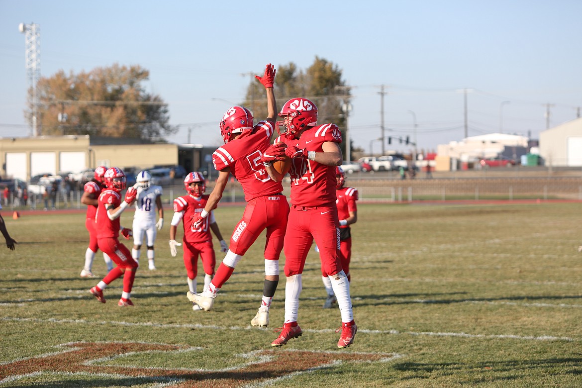 Othello seniors Adriel Deleon (5) and Julian Alegria (44) leap up in the air in celebration of Alegria’s touchdown run in the second quarter of Othello’s 49-12 win over Washington on Saturday.