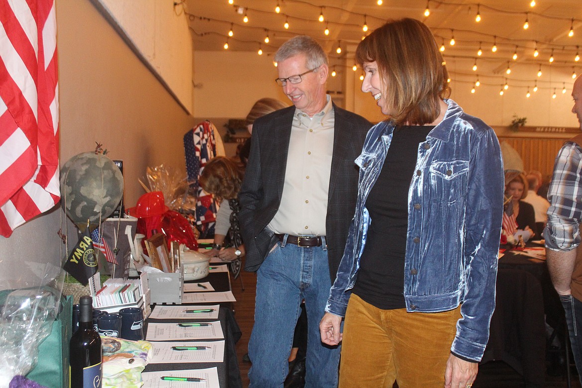 Attendees look over the items in the silent auction during the fundraising banquet sponsored by the Quincy Valley Chamber of Commerce and the Quincy Rotary Club.