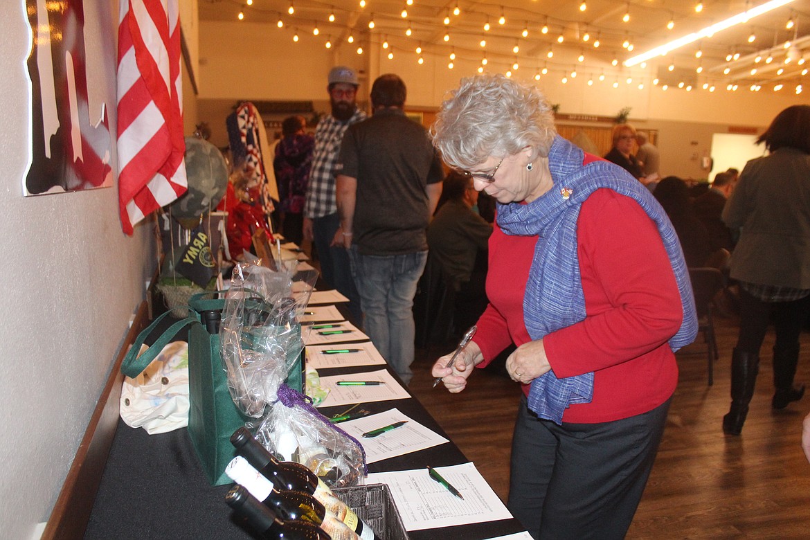 Harriet Weber places a bid on an item in the silent auction Saturday night.