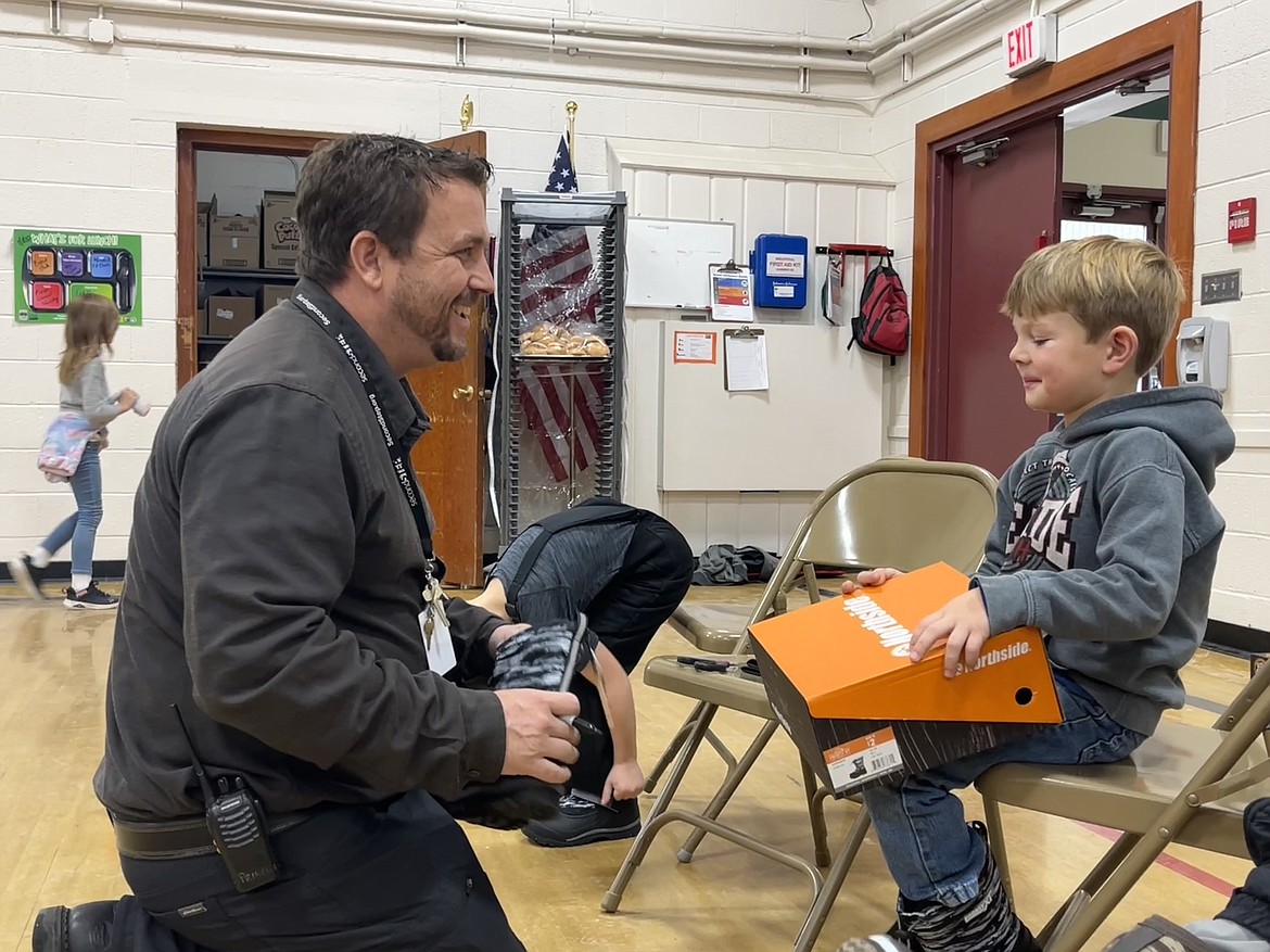 Principal TJ Clary helped one of his student fit a new pair of boots