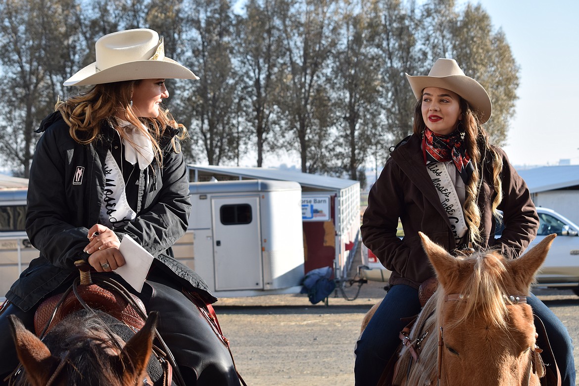 Outgoing Miss Moses Lake Roundup Brianna Kin Kade (left) and contestant Jenna Penrose sit on the horses and talk outside the Harwood Pavillion at the Grant County Fairgrounds during the horsemanship portion of the Miss Moses Lake Roundup pageant on Saturday.