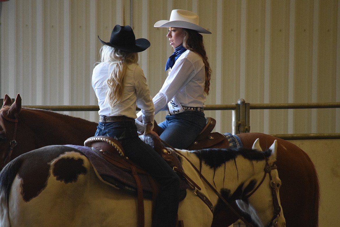 Miss Moses Lake Roundup contestants Annabelle Booth (left) and Alexis Shoults talk as they prepare to compete during the pageant’s horsemanship round on Saturday morning.