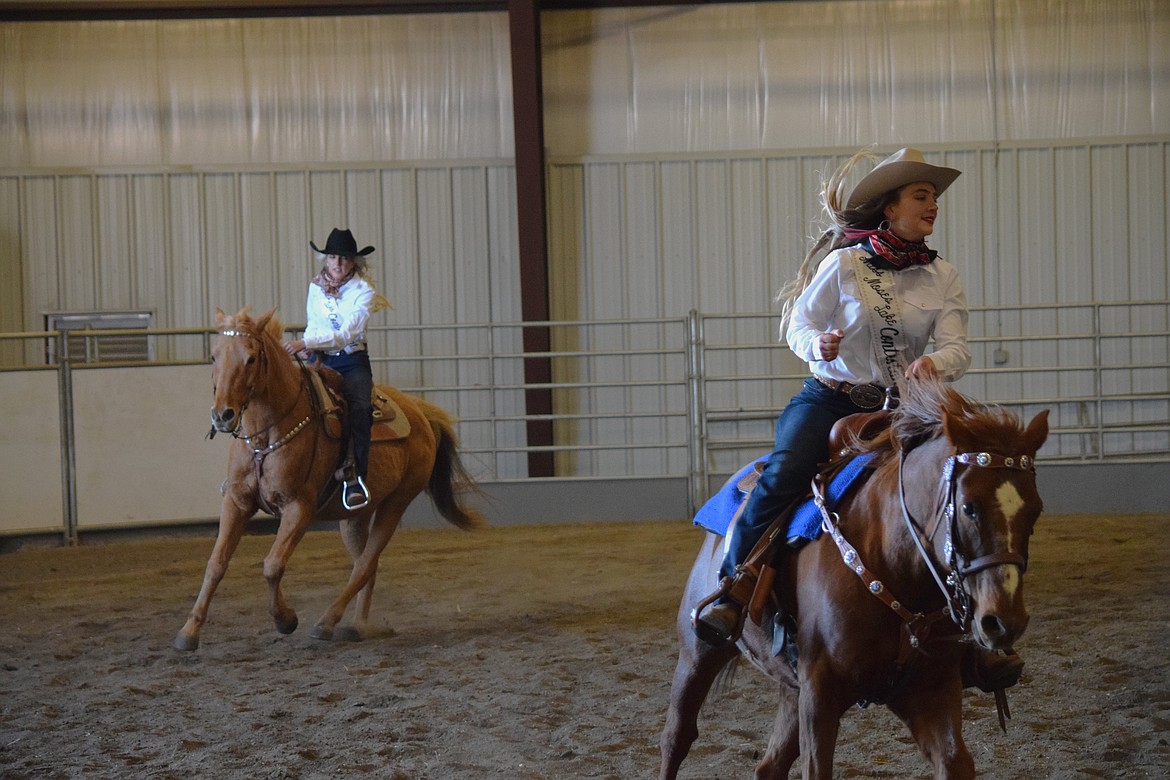 Annabelle Booth (left) and Jenna Penrose (right) ride the rail as part of the Miss Moses Lake Roundup pageant’s horsemanship competition on Saturday.